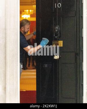 Londres, Royaume-Uni. 23rd septembre 2022. Man nettoie la porte d'entrée du 10 Downing Street Londres. Crédit : Ian Davidson/Alay Live News Banque D'Images