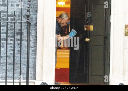 Londres, Royaume-Uni. 23rd septembre 2022. Man nettoie la porte d'entrée du 10 Downing Street Londres. Crédit : Ian Davidson/Alay Live News Banque D'Images