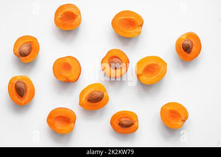 les moitiés d'abricots piqués se trouvent sur un fond clair dans un ordre aléatoire, vue du dessus Banque D'Images