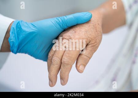 Médecin tenant des mains en contact asiatique senior ou âgée vieille femme patiente avec amour, soins, aide, encourager et empathie à la salle d'hôpital de soins infirmiers, concept médical sain et fort Banque D'Images