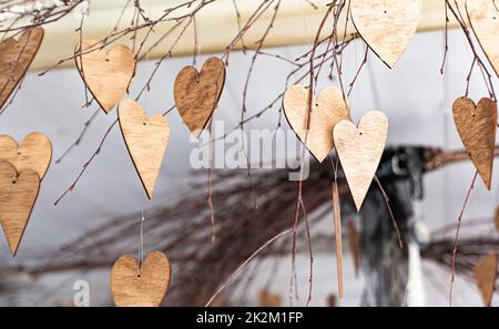 Ornements en forme de coeurs. Ornements en bois sur les branches. Coeurs coupés en bois. Thème de l'automne. Banque D'Images