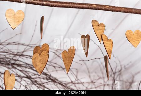 Ornements en forme de coeurs. Ornements en bois sur les branches. Coeurs coupés en bois. Thème de l'automne. Banque D'Images