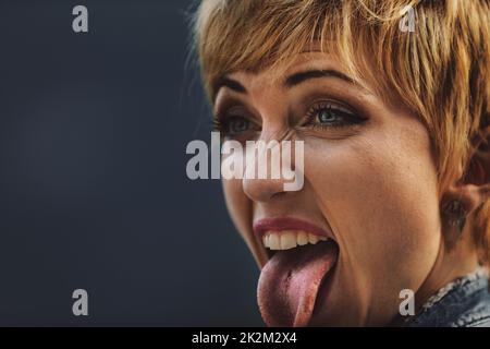 Jeune femme avec piercing collant hors de sa langue Banque D'Images