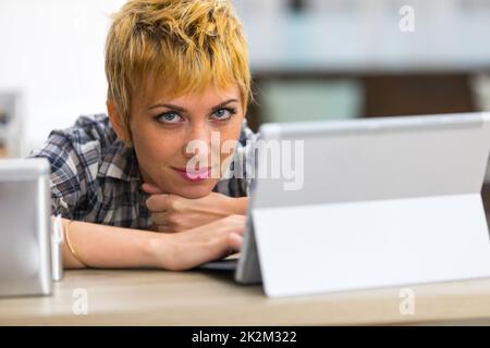 Une femme attentionnés reposant son menton sur ses mains Banque D'Images