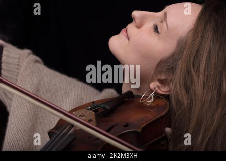 musicien de violon passionné jouant sur fond noir Banque D'Images