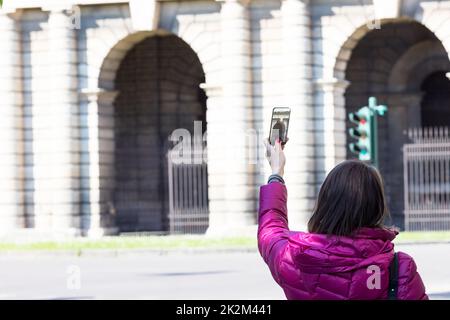 femme dans une ville prenant des photos avec téléphone transparent Banque D'Images