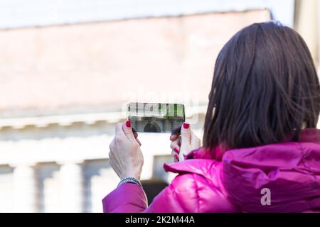 femme dans une ville prenant des photos avec téléphone transparent Banque D'Images