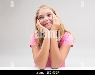 une fille souriante imagine quelque chose ou rêve Banque D'Images