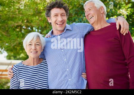 Il nous rend si fiers. Portrait court d'un couple senior debout à l'extérieur avec son fils. Banque D'Images