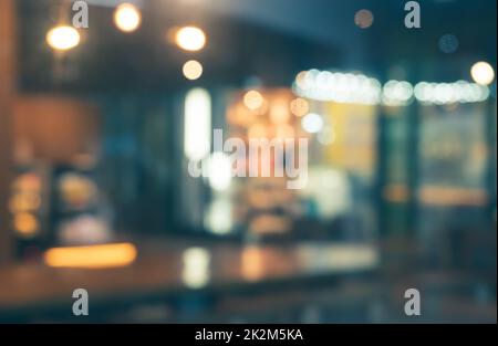 Café-restaurant, arrière-plan flou avec lumières de nuit bokeh. Banque D'Images