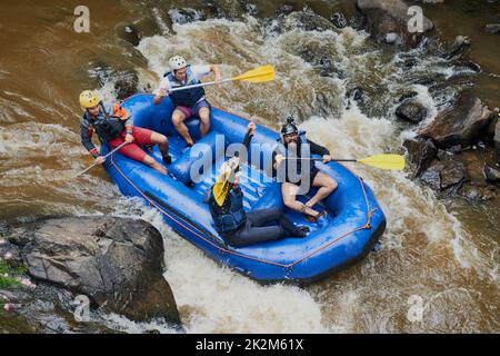 Les rapides ne sont pas apprivoés uniquement avec le flux. Photo d'un groupe de jeunes amis en rafting. Banque D'Images