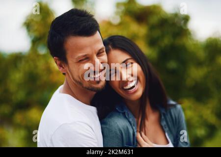 L'amour est ce qui rend la vie belle. Photo d'un jeune couple affectueux qui passe une journée romantique dans le parc. Banque D'Images