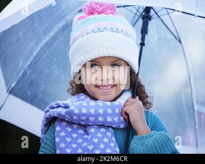 J'ai attendu la pluie toute la semaine. Photo d'une adorable petite fille debout seule à l'extérieur et tenant un parapluie. Banque D'Images