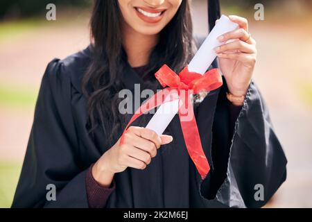 Fête de la remise des diplômes. Photo courte d'une jeune étudiante méconnue qui célèbre le jour de la remise des diplômes. Banque D'Images