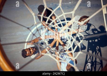 Basketball, teamwork and sport with a team of basket ball players with their hands in a huddle on a court outside. Collaboration, motivation and Stock Photo