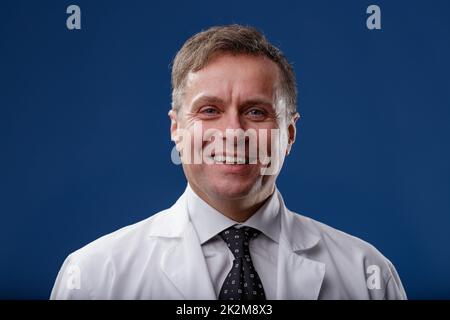 Portrait d'un homme d'âge moyen souriant dans un manteau de laboratoire blanc Banque D'Images