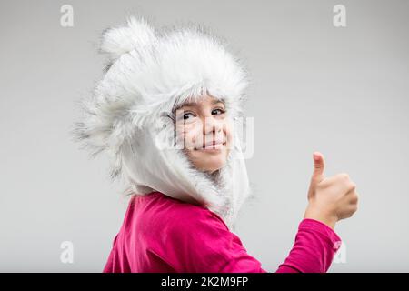 Préadolescence fille portant une casquette moelleuse donnant le pouce vers le haut Banque D'Images