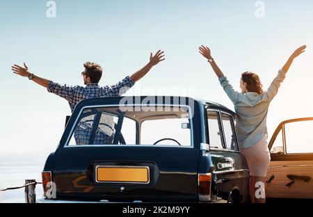 Vous n'êtes libre que si vous utilisez votre liberté. Vue arrière d'un couple enjoué sur un voyage en voiture. Banque D'Images