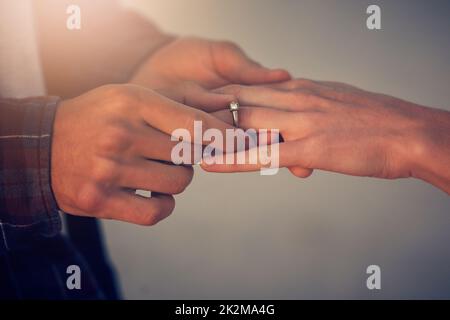 Il est temps de passer à l'étape suivante. Photo courte d'un jeune homme mettant un anneau d'engagement sur le doigt de ses amies. Banque D'Images