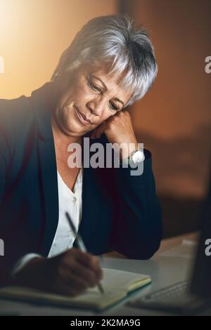 Elle ne s'arrêtera pas jusqu'à ce que le plan soit parfait. Photo d'une femme d'affaires mûre qui écrit dans un ordinateur portable en fin de soirée au travail. Banque D'Images