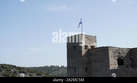 Les ruines du poste de police de mandat britannique à Ein Tina au début de la réserve naturelle d'Amud Stream, en haute Galilée, dans le nord d'Israël. Bâtiment en béton historique avec drapeau israélien sur le dessus Banque D'Images