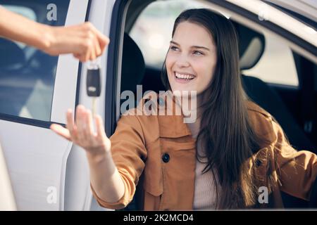 Les voitures que nous conduisons en disent long sur nous. Photo d'une personne donnant à une femme les clés de sa nouvelle voiture à l'extérieur. Banque D'Images