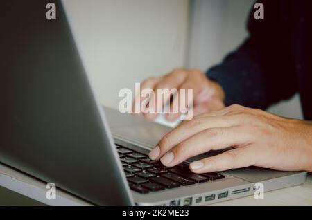 Homme main à l'aide d'un ordinateur pour taper sur un clavier pour trouver des informations sur Internet sur les réseaux sociaux. Banque D'Images
