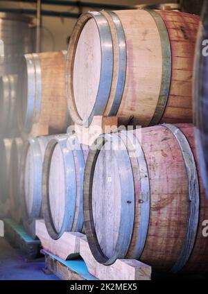 De ceux qui savent le mieux. Prise de barils de vin empilés les uns sur les autres dans une distillerie de vin. Banque D'Images