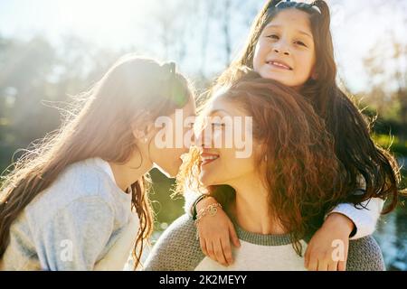 Mes petites filles sont si précieuses. Photo courte d'une belle jeune mère et de ses adorables filles à l'extérieur. Banque D'Images