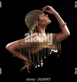 Laissez votre déesse intérieure prendre vie. Photo courte d'une jeune femme élégante et élégante qui se pose sur un fond sombre. Banque D'Images