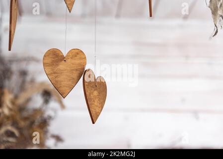 Ornements en forme de coeurs. Ornements en bois sur les branches. Coeurs coupés en bois. Thème de l'automne. Banque D'Images