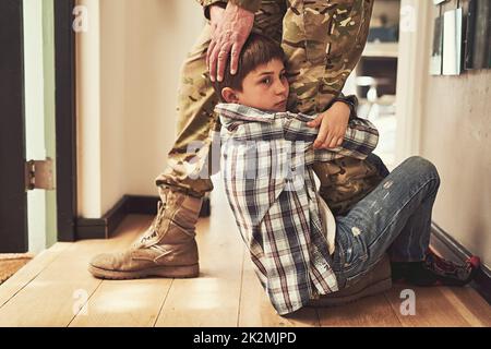 Ne me laissez pas papa. Un jeune garçon s'accrochant à la jambe de son père pour l'empêcher de se rendre à l'armée. Banque D'Images