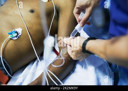 Administration de médicaments par perfusion IV.Injection d'un médecin en vue de l'insertion d'une goutte iv dans le bras d'un patient dans une salle d'urgence. Banque D'Images