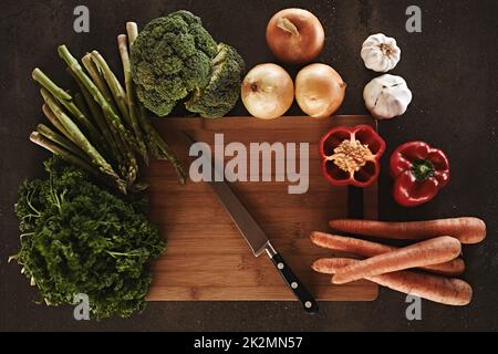 À vos marques, prêts, hachez. Légumes sur une planche à découper. Banque D'Images