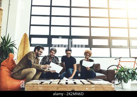 Générer des idées utiles. Photo d'un groupe de jeunes concepteurs discutant de la paperasse. Banque D'Images