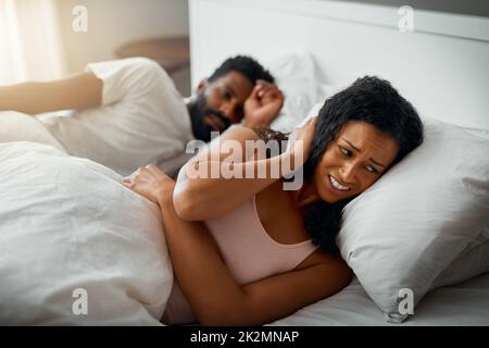 Je ne peux pas dormir comme ça. Plan court d'une belle femme agacée par ses beaux maris ronflant dans le lit à la maison. Banque D'Images