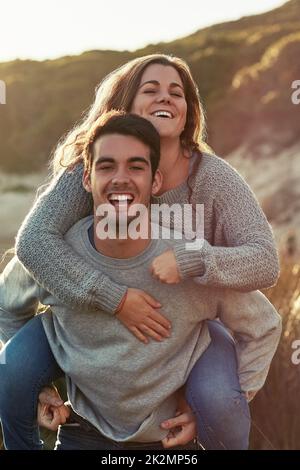 Quelle journée parfaite pour être ensemble. Portrait d'un jeune couple se relaxant sur la plage ensemble le week-end. Banque D'Images