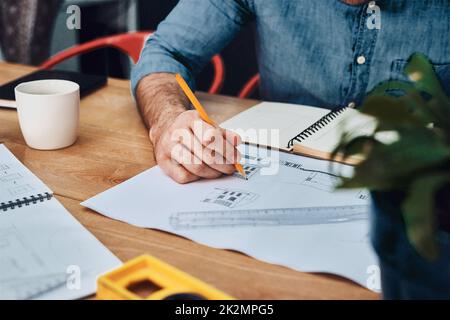 HES a obtenu ce qu'il faut pour produire des conceptions de référence. Photo rognée d'un architecte masculin méconnu travaillant avec des plans dans un bureau moderne. Banque D'Images