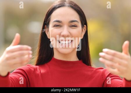 Femme en rouge disant venir avec moi dans un parc Banque D'Images