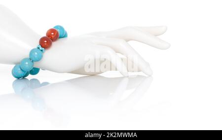 Turquoise avec bijou de Carnélian ou bracelet de pierres précieuses sur la main femelle de mannequin en plastique. Collection d'accessoires en pierres précieuses naturelles. Prise de vue en studio Banque D'Images