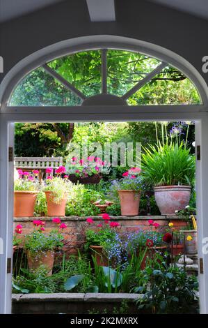 Portrait d'une vue sur le jardin par des portes doubles ouvertes. Banque D'Images