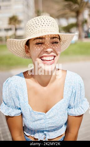 Chapeau de voyage et fille d'été avec le sourire en profitant de la chaleur du soleil extérieur temps de vacances. Jeune, belle et heureuse femme latino se détendant sur la passerelle Banque D'Images