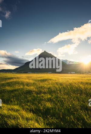 Magnifique coucher de soleil sur la montagne de Stapafell et prairie lumineuse dans le village d'Arnarstapi en été à l'Islande Banque D'Images