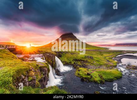 Paysage fantastique de coucher de soleil sur la montagne Kirkjufell avec la cascade Kirkjufellsfoss et le nuage pileus coloré l'été à l'Islande Banque D'Images