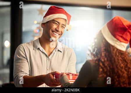 Boxing day. Secret Santa. Parti d'hiver. Party de Noël de bureau. Heureux l' homme et la femme porter santa hats. Cheerful couple fêter le nouvel an.  Fête de Noël. Donner en cadeau. Ambiance