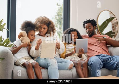 L'apprentissage peut se faire de deux façons différentes. Photo d'une jeune famille passant du temps ensemble et utilisant une tablette numérique à la maison. Banque D'Images