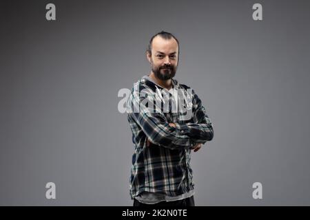 Portrait demi-tour d'un homme barbu avec les bras pliés Banque D'Images