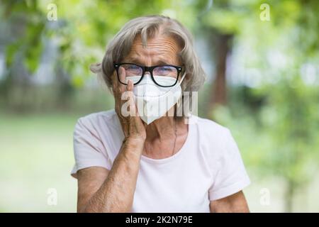 Femme âgée portant un masque de protection contre les virus Banque D'Images