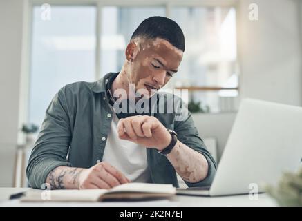 Ne laissez pas la peur de perdre vous arrêter. Photo d'un jeune homme d'affaires qui vérifie sa montre dans un bureau moderne. Banque D'Images