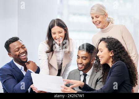 C'est une idée si brillante. Photo d'une équipe de gens d'affaires lisant des documents au cours d'une réunion. Banque D'Images